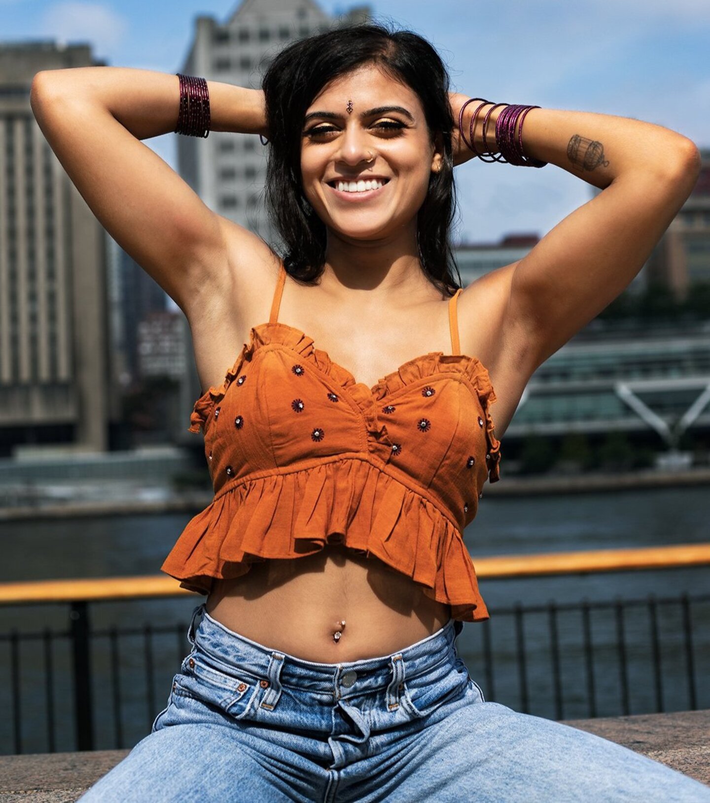 Portrait of Anjali wearing an orange shirt.