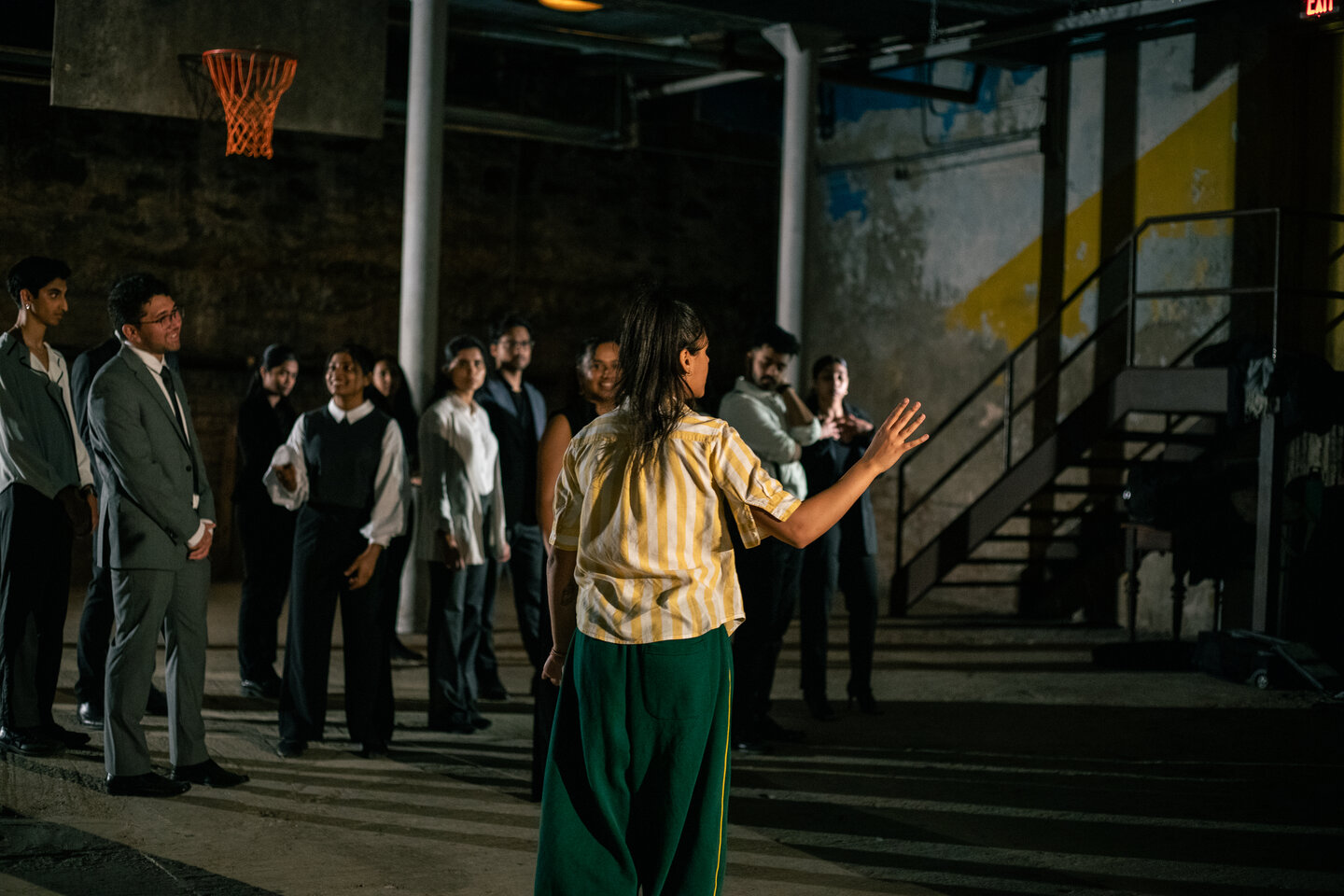 Anjali Kapur facing a crowd of suited dancers in the Undecided concept video
